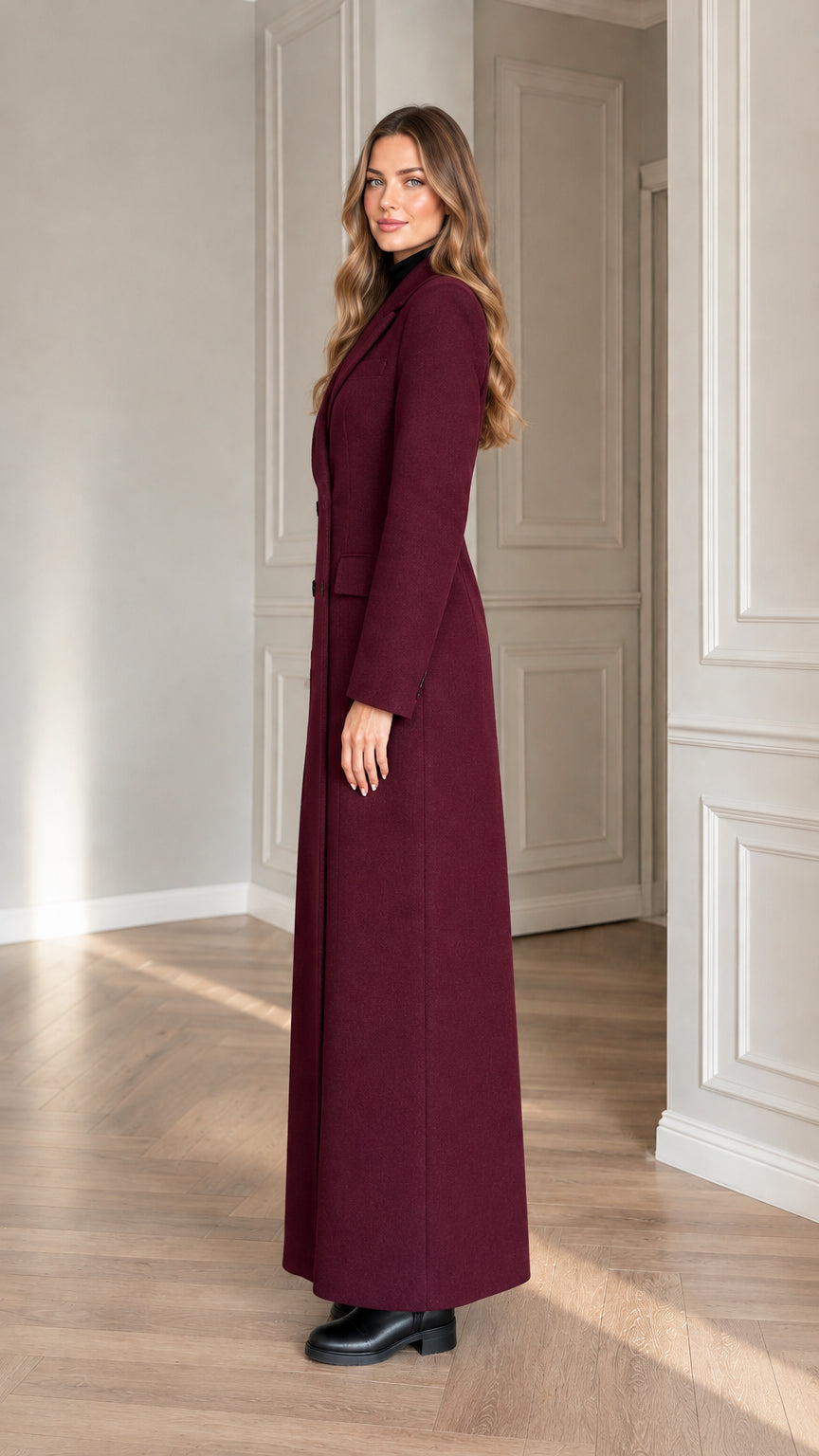 Side profile view of woman wearing burgundy long maxi overcoat