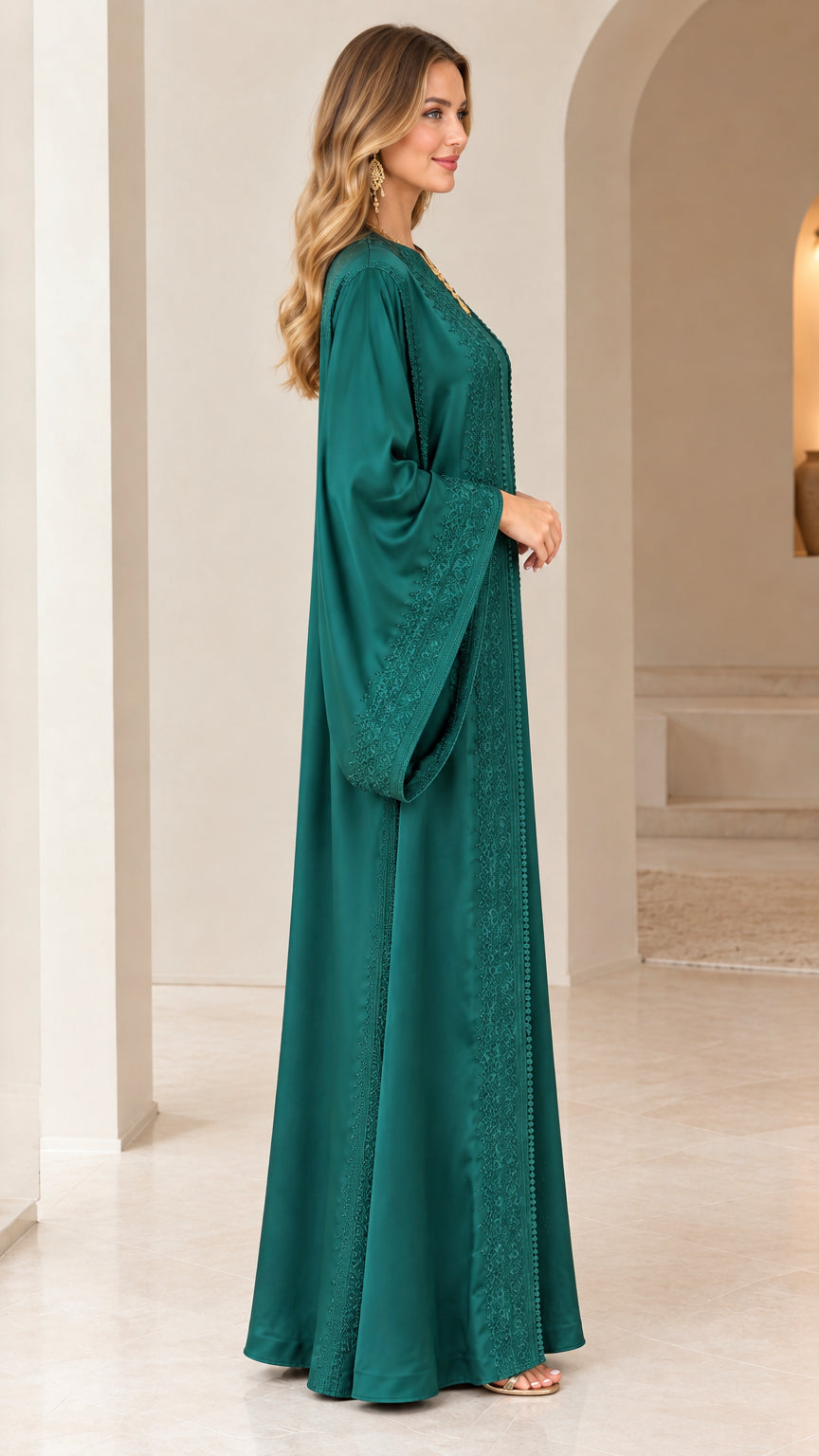 Side profile view of woman wearing emerald green flowing caftan maxi dress