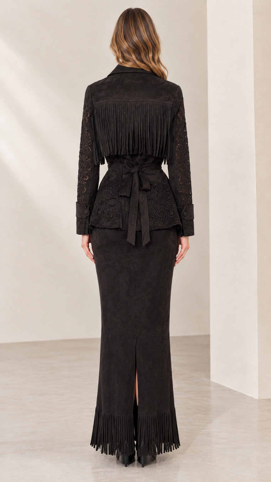 Back view of black fringe jacket showing tie waist and slit maxi skirt