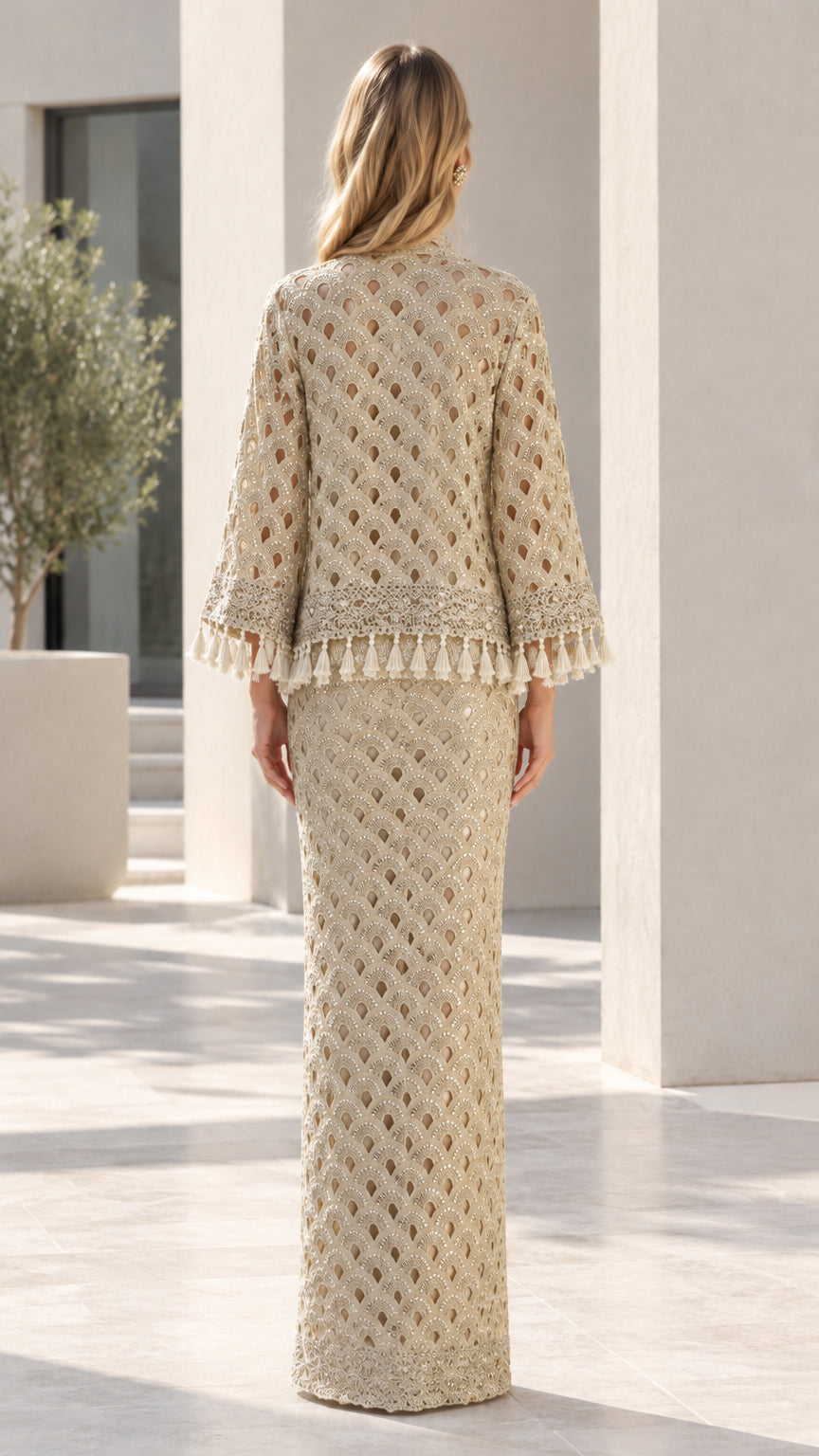 Back view of woman wearing Champagne embellished maxi skirt and tassel cardigan set