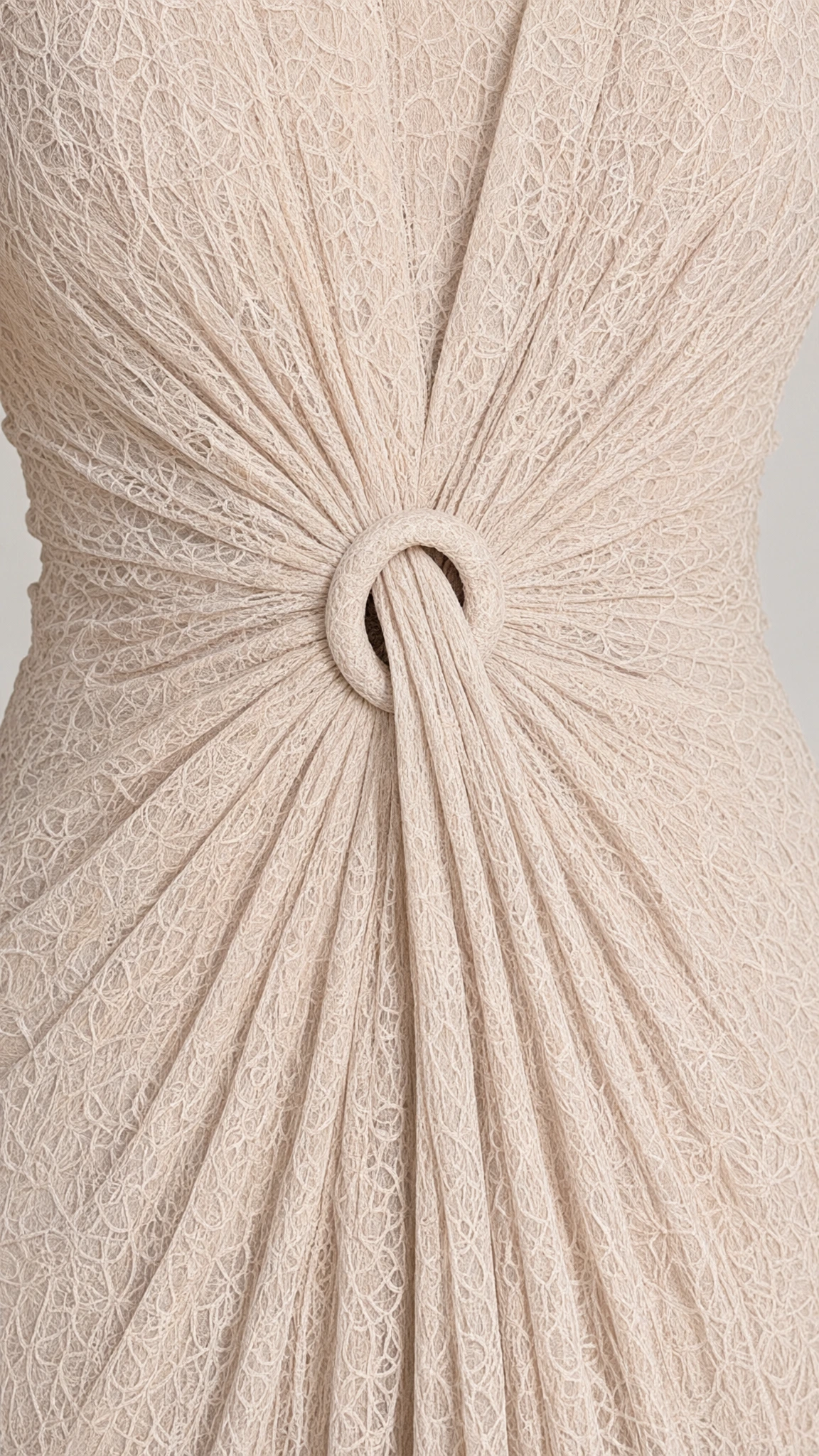 Close-up detail of the gathered lace waist and central ring accent