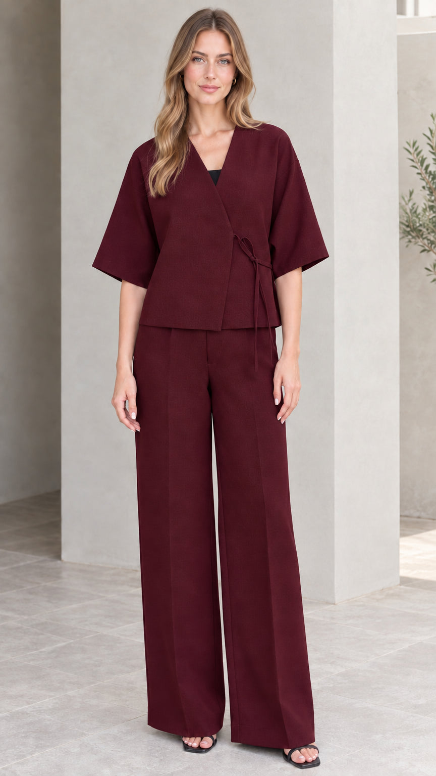 Full-length view of model wearing burgundy wine wrap top and wide-leg pant set
