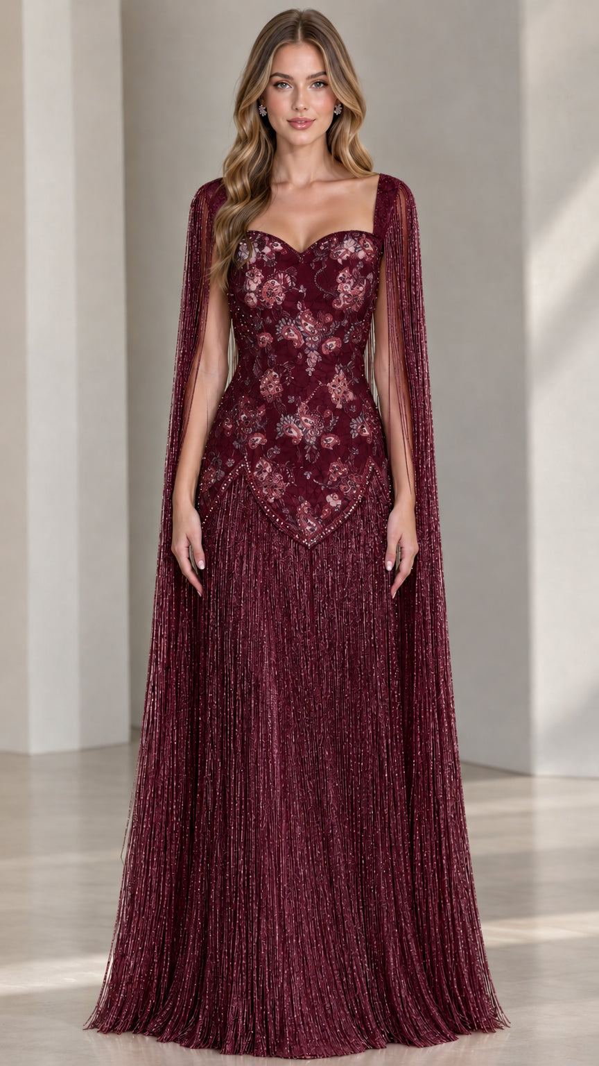 Model wearing burgundy wine red cape sleeve fringe formal dress