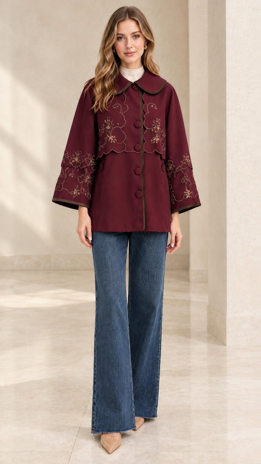 Full-length front view of woman wearing burgundy wine embroidered scalloped capelet jacket