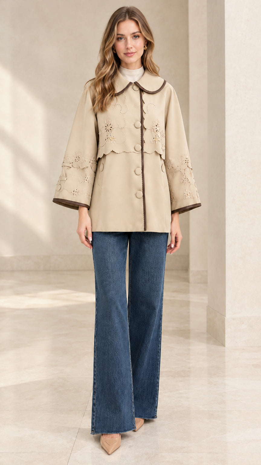 Full-length front view of woman wearing beige embroidered scalloped capelet jacket