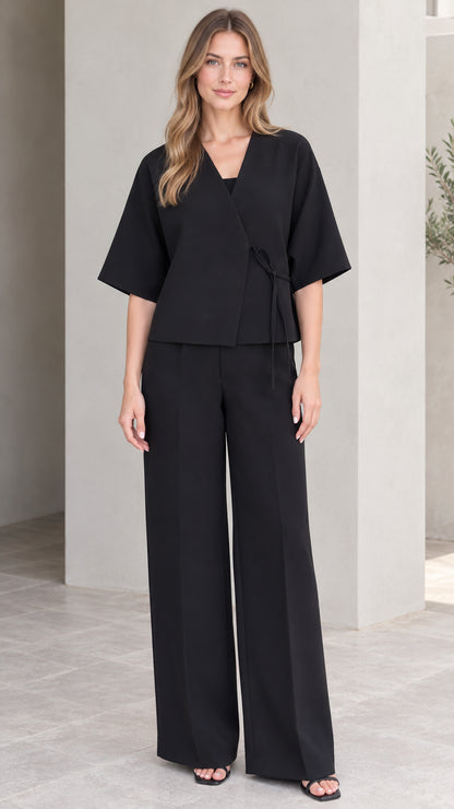 Front full-length view of model wearing black wrap top and wide-leg trousers set