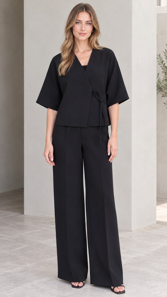 Front full-length view of model wearing black wrap top and wide-leg trousers set
