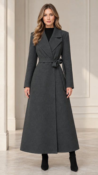 Front full-length view of woman wearing a charcoal grey belted maxi overcoat with notched lapels