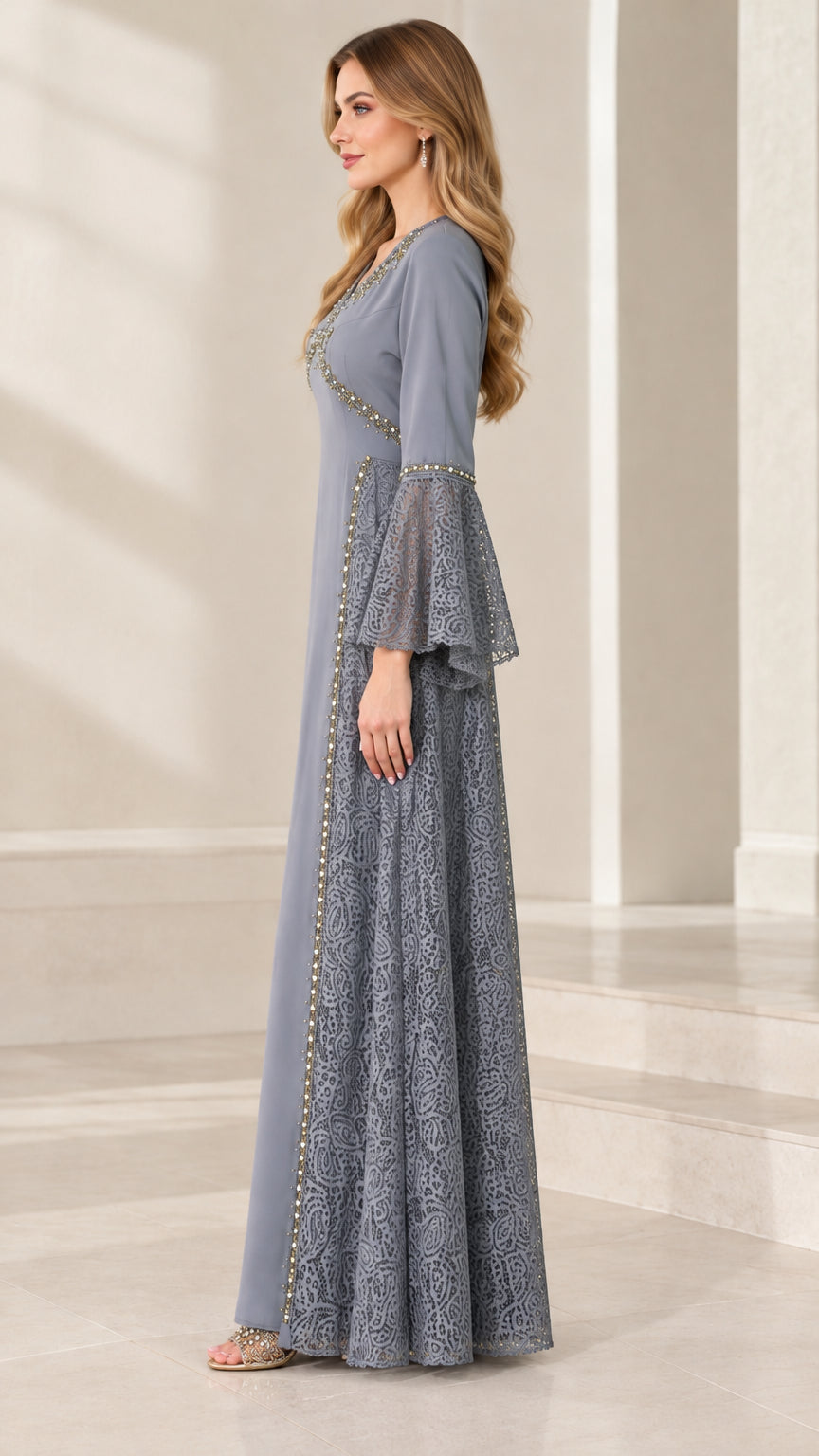 Side profile view of the dusty blue floor-length gown showing lace side inserts