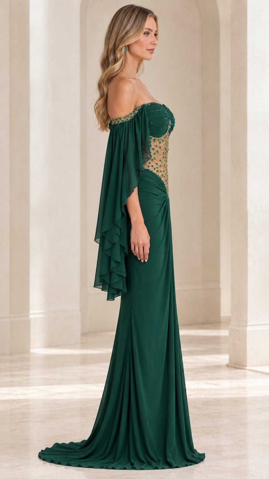 Side profile view of emerald green evening dress highlighting sheer embellished bodice and draped train