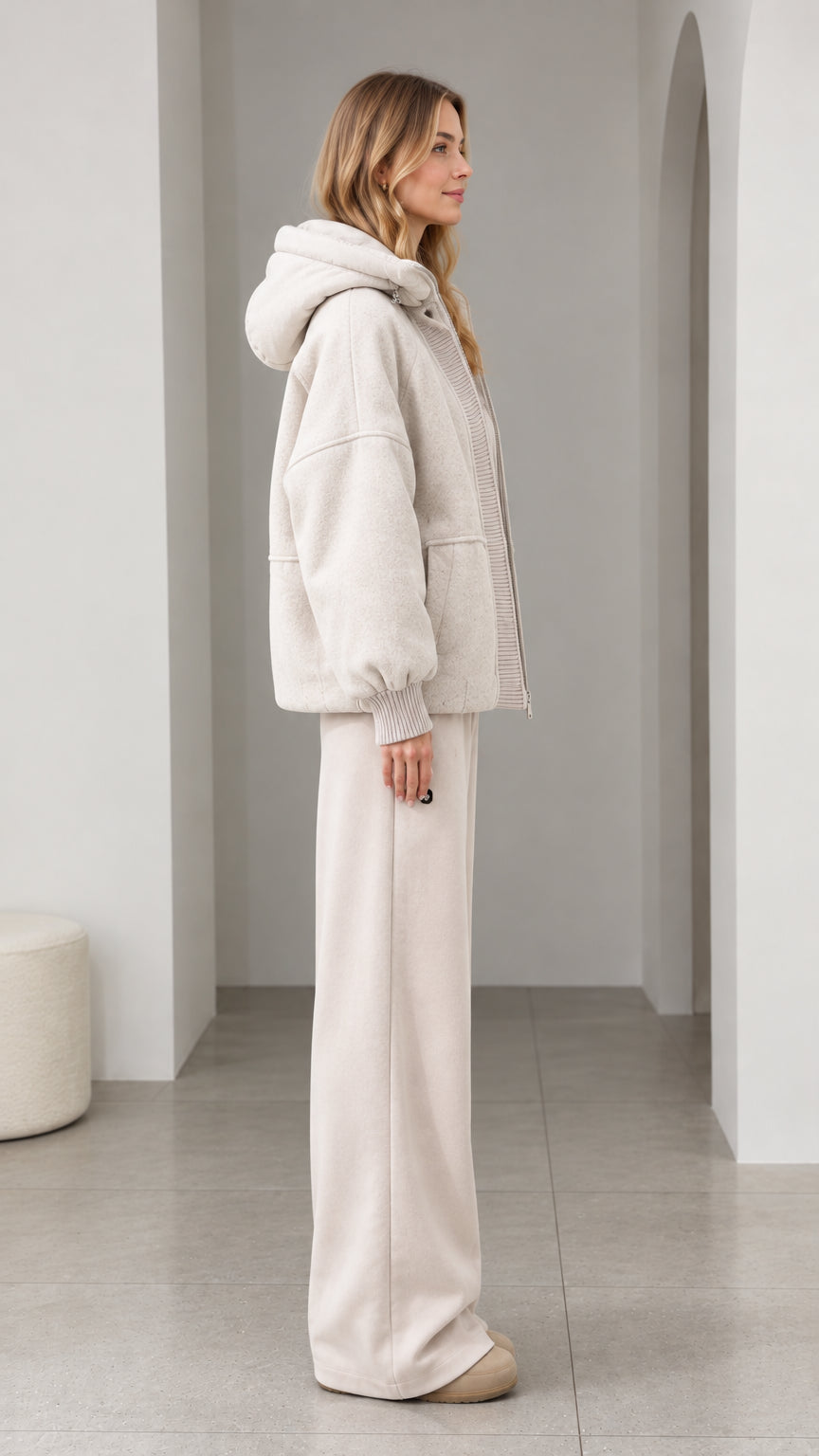 Side profile of model wearing cream textured fleece hooded jacket