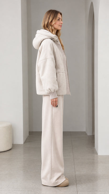 Side profile of model wearing cream textured fleece hooded jacket