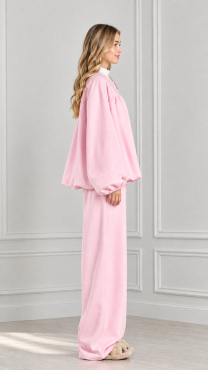 Side profile of model in light pink balloon sleeve jacket and wide-leg pants