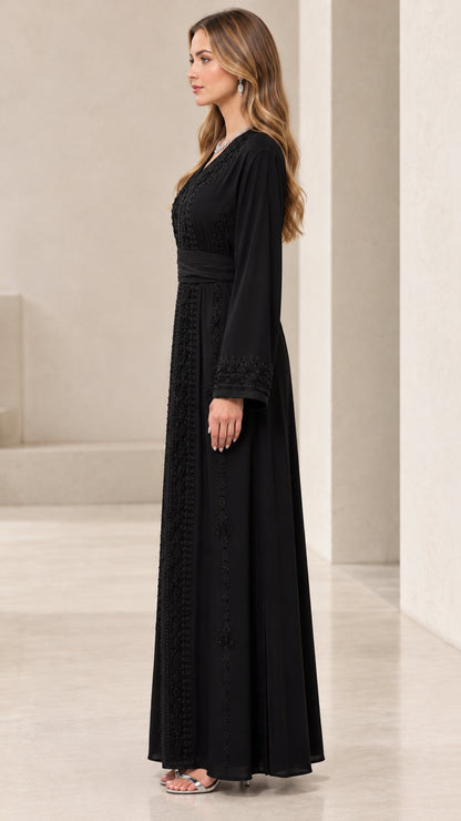 Side profile view of black embroidered maxi dress showing flowing drape