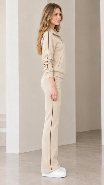 Side view of beige tracksuit set showing contrast vertical stripes along jacket and pants