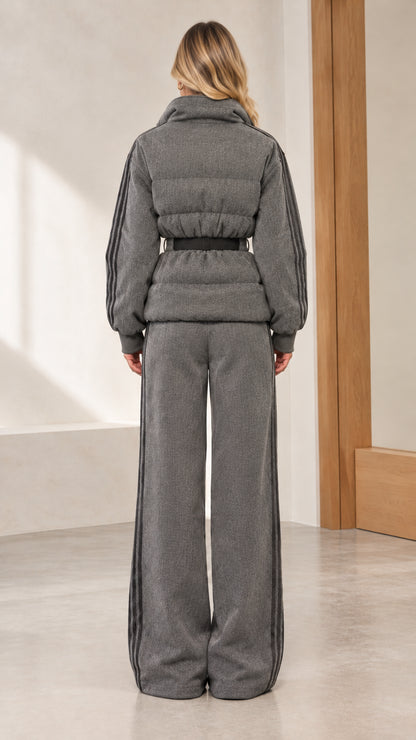 Back view of woman wearing grey quilted puffer jacket and wide-leg track pants
