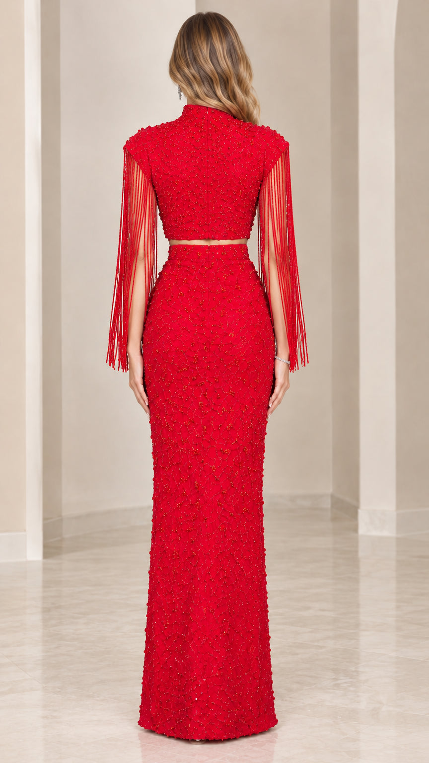 Back full-length view of red beaded two-piece evening gown showing zipper and fringe