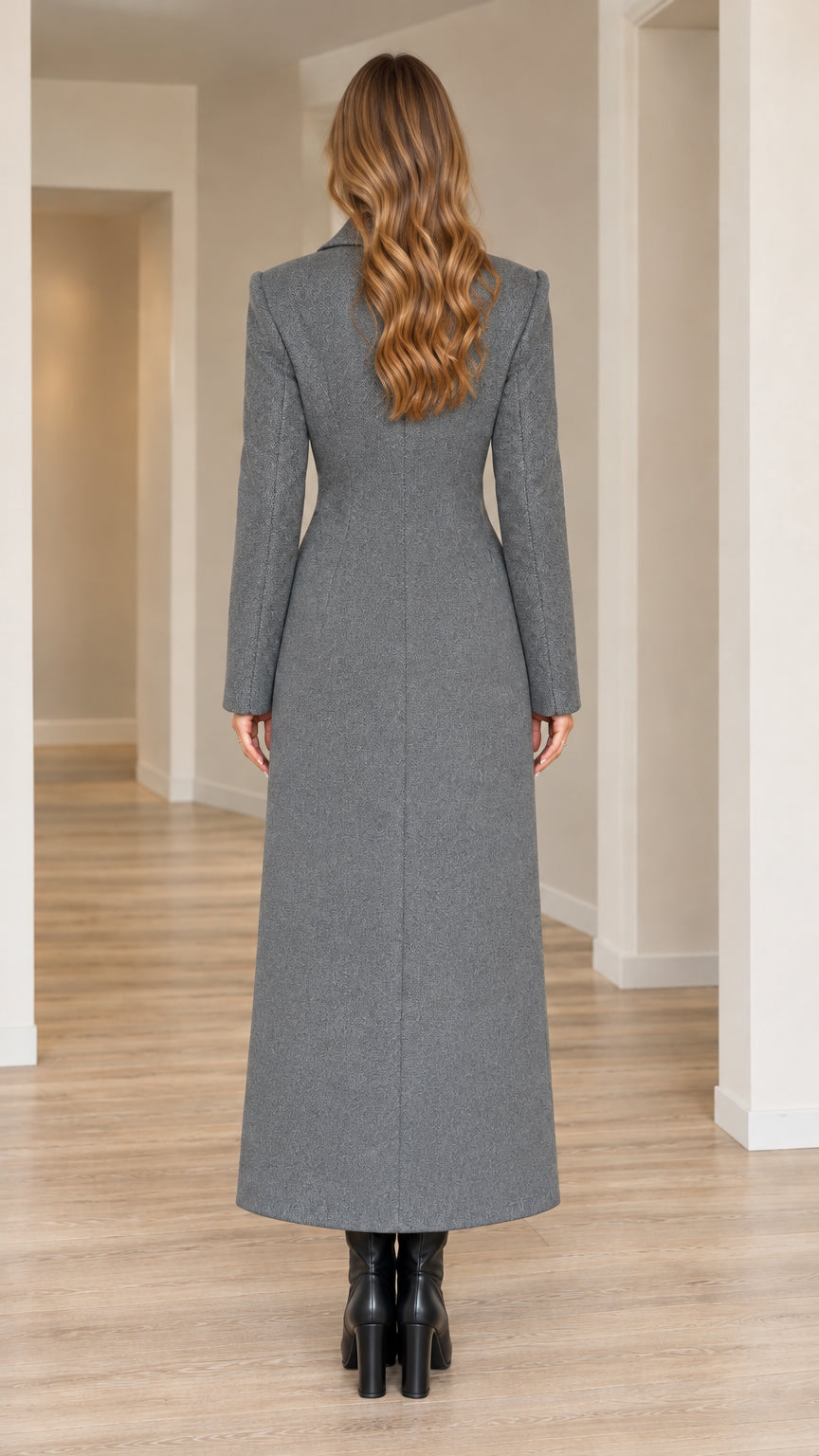 Back view of model in grey maxi overcoat showcasing structured seam lines