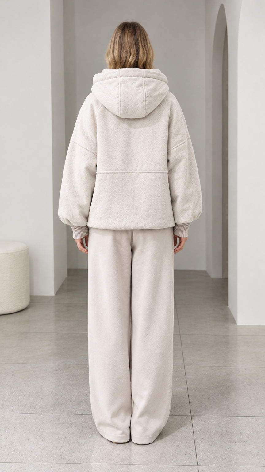 Back view of model wearing cream textured fleece hooded jacket and lounge pants