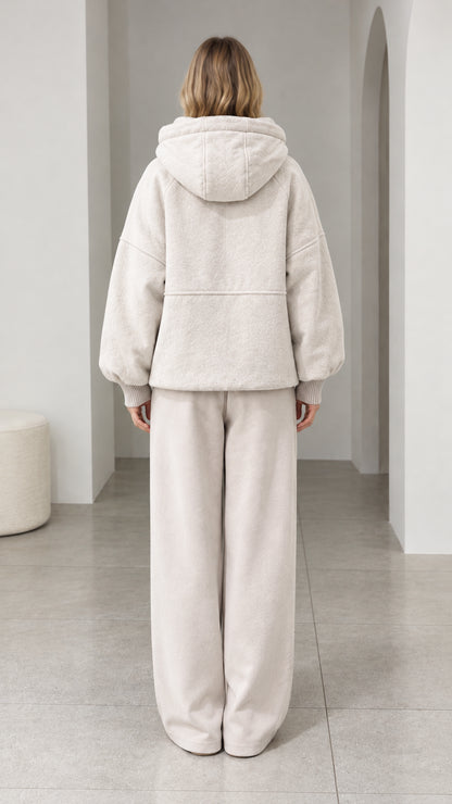 Back view of model wearing cream textured fleece hooded jacket and lounge pants