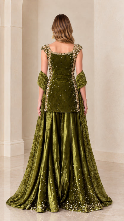Back view of woman in sleeveless olive green embellished velvet tunic and flared skirt