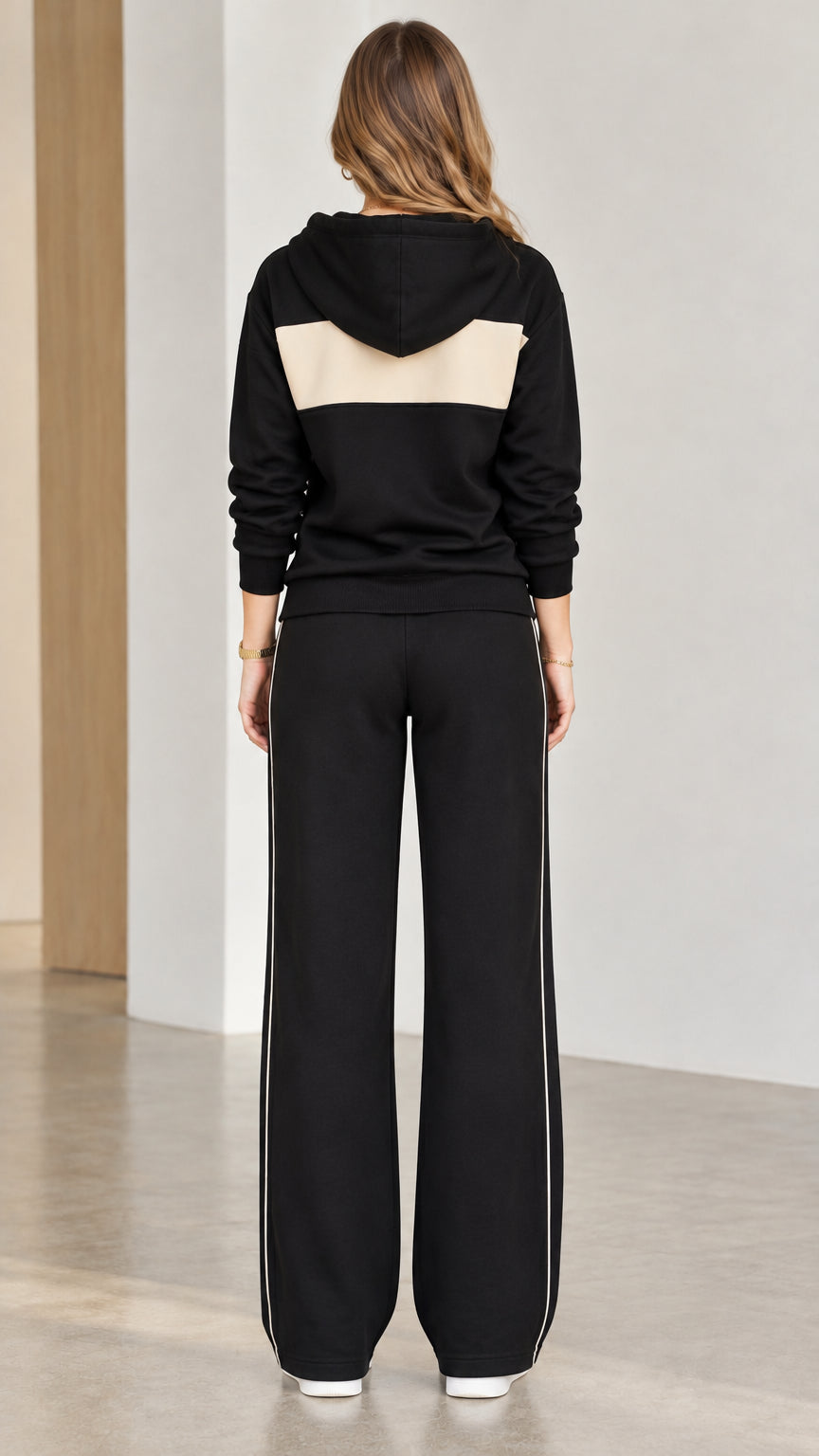 Back view of black hooded sweatshirt with contrast panel and wide-leg pants