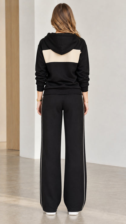 Back view of black hooded sweatshirt with contrast panel and wide-leg pants