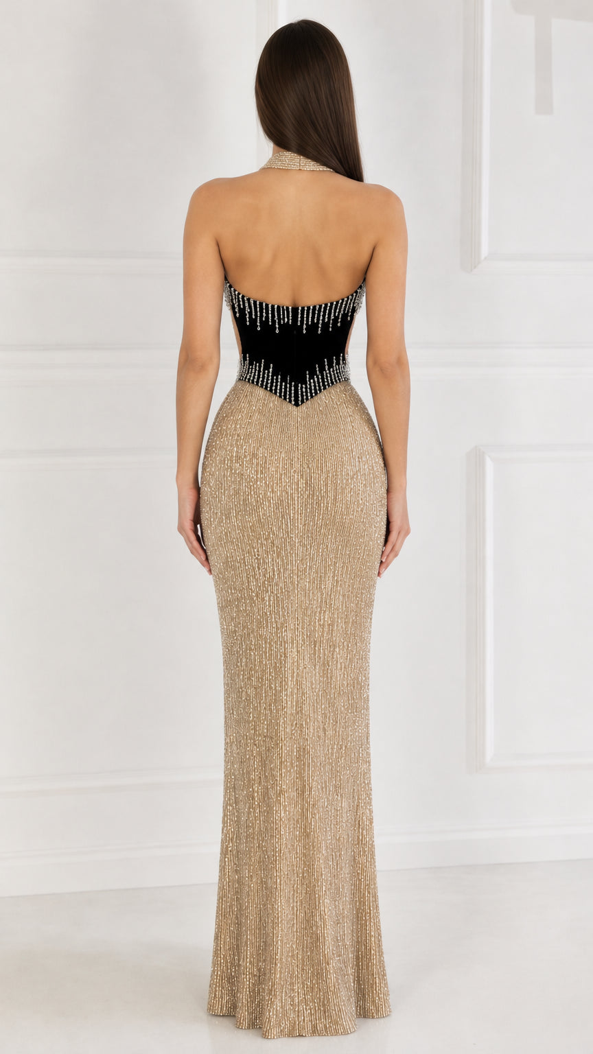Back view of woman wearing gold backless halter maxi gown