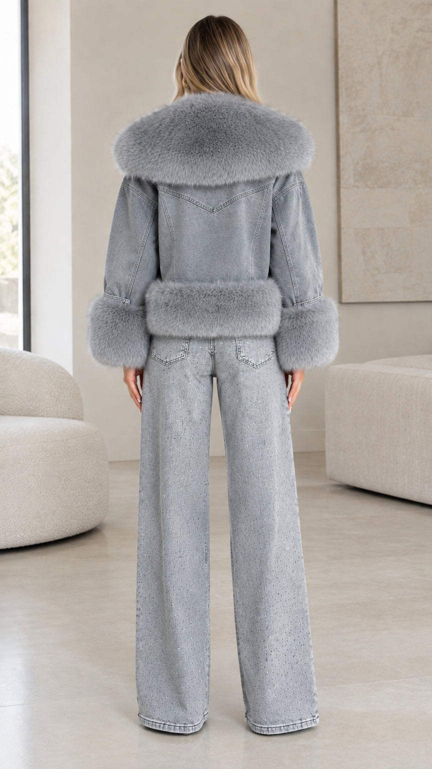 Back view of model showing grey denim jacket with faux fur collar and hem