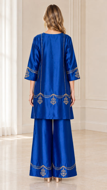Back view of model wearing royal blue two-piece embroidered pant set