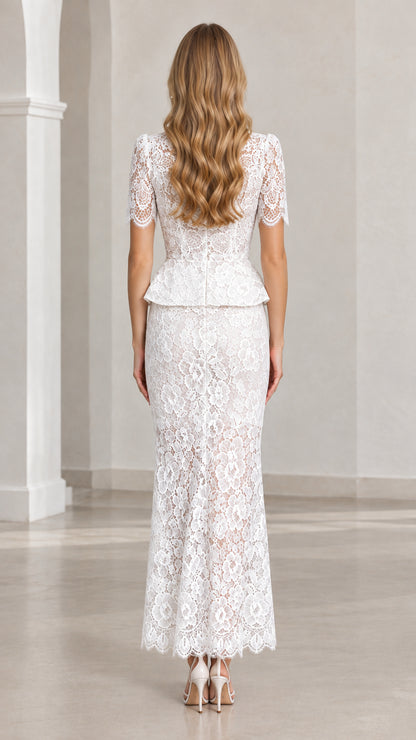 Back view of woman wearing white lace peplum top and column maxi skirt