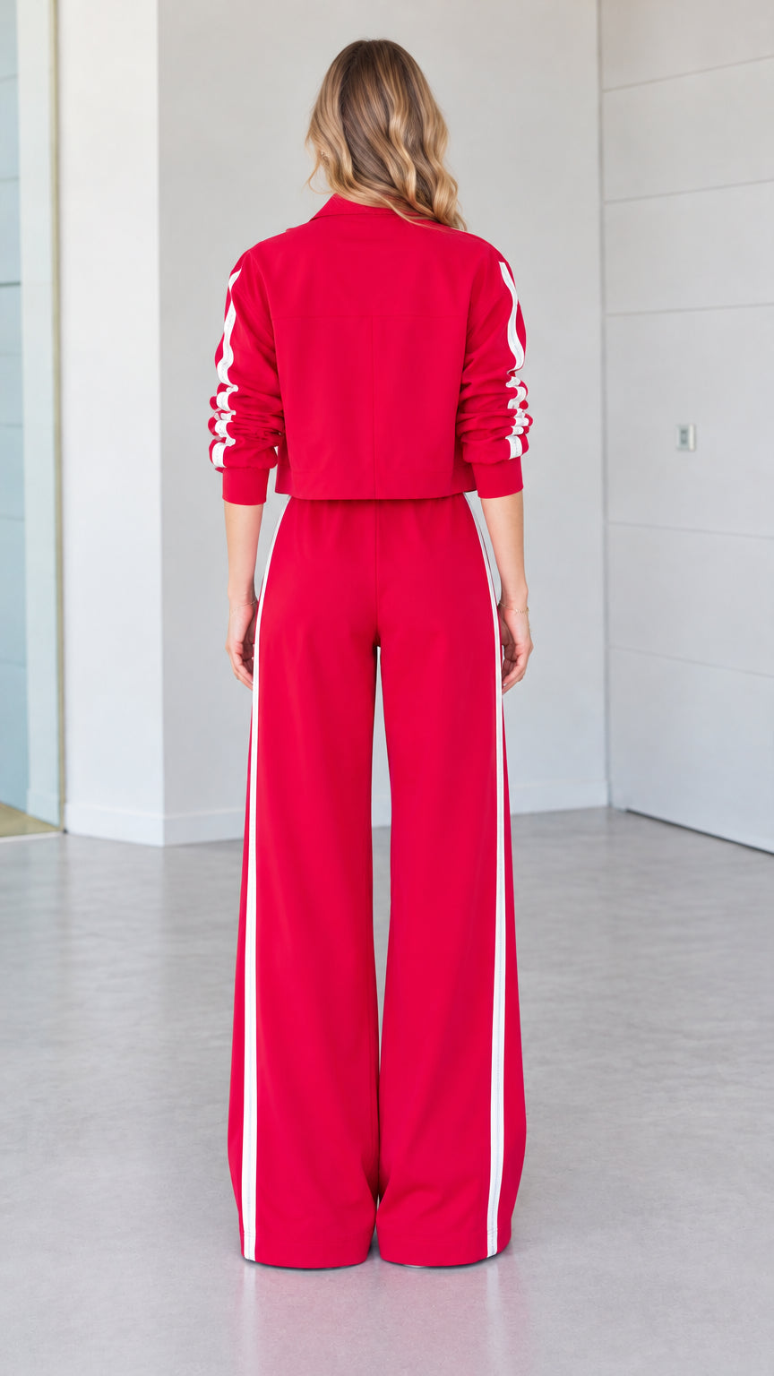 Back view of woman wearing red cropped jacket and wide-leg tracksuit pants