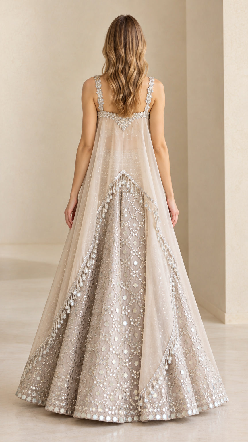 Back view of flowing sheer cape overlay and sequined maxi skirt in champagne