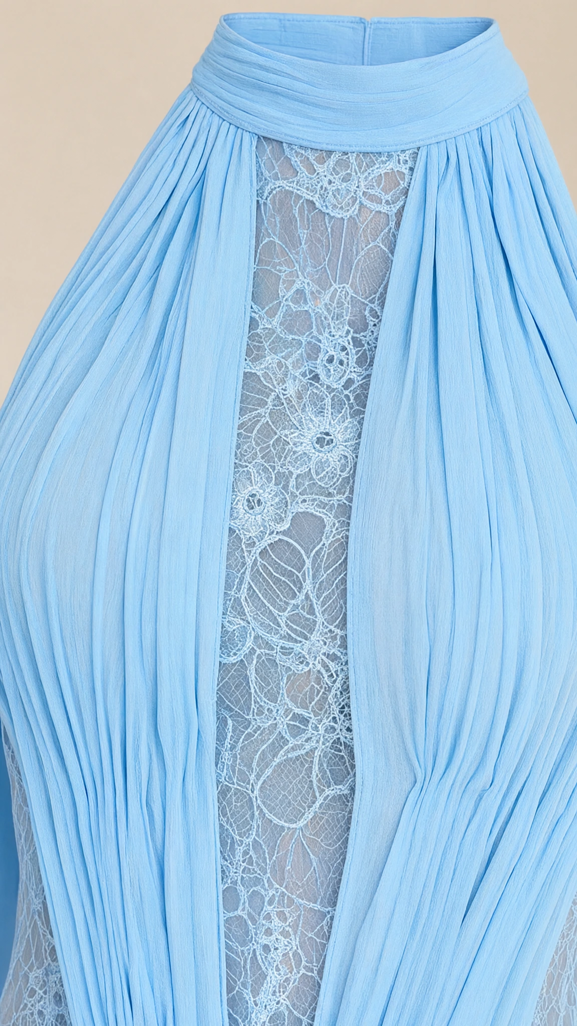 Close-up detail of halter neckline, pleating, and intricate sheer lace insert