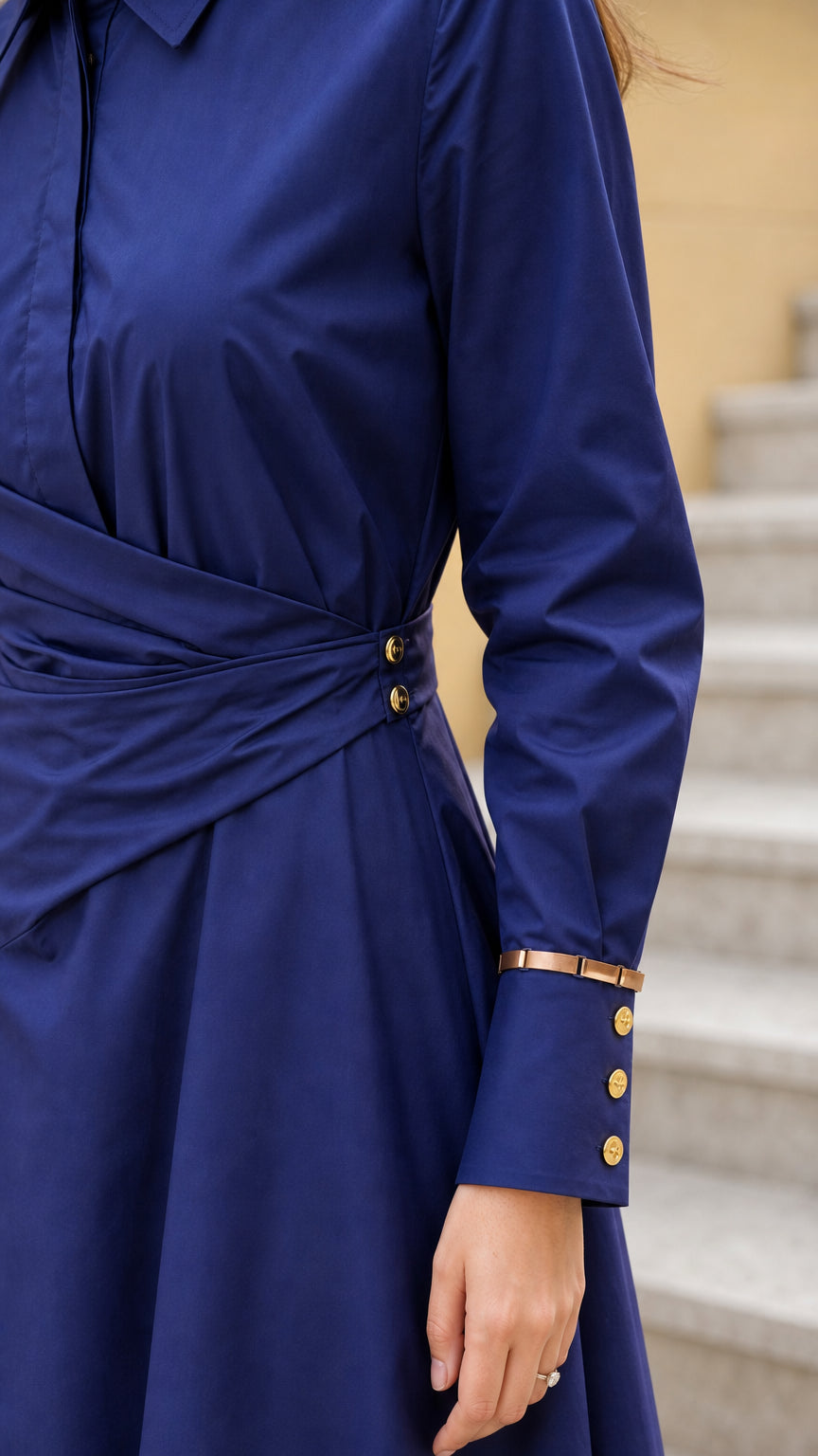 Close-up of bodice, wrap detail, and sleeve cuffs on navy dress