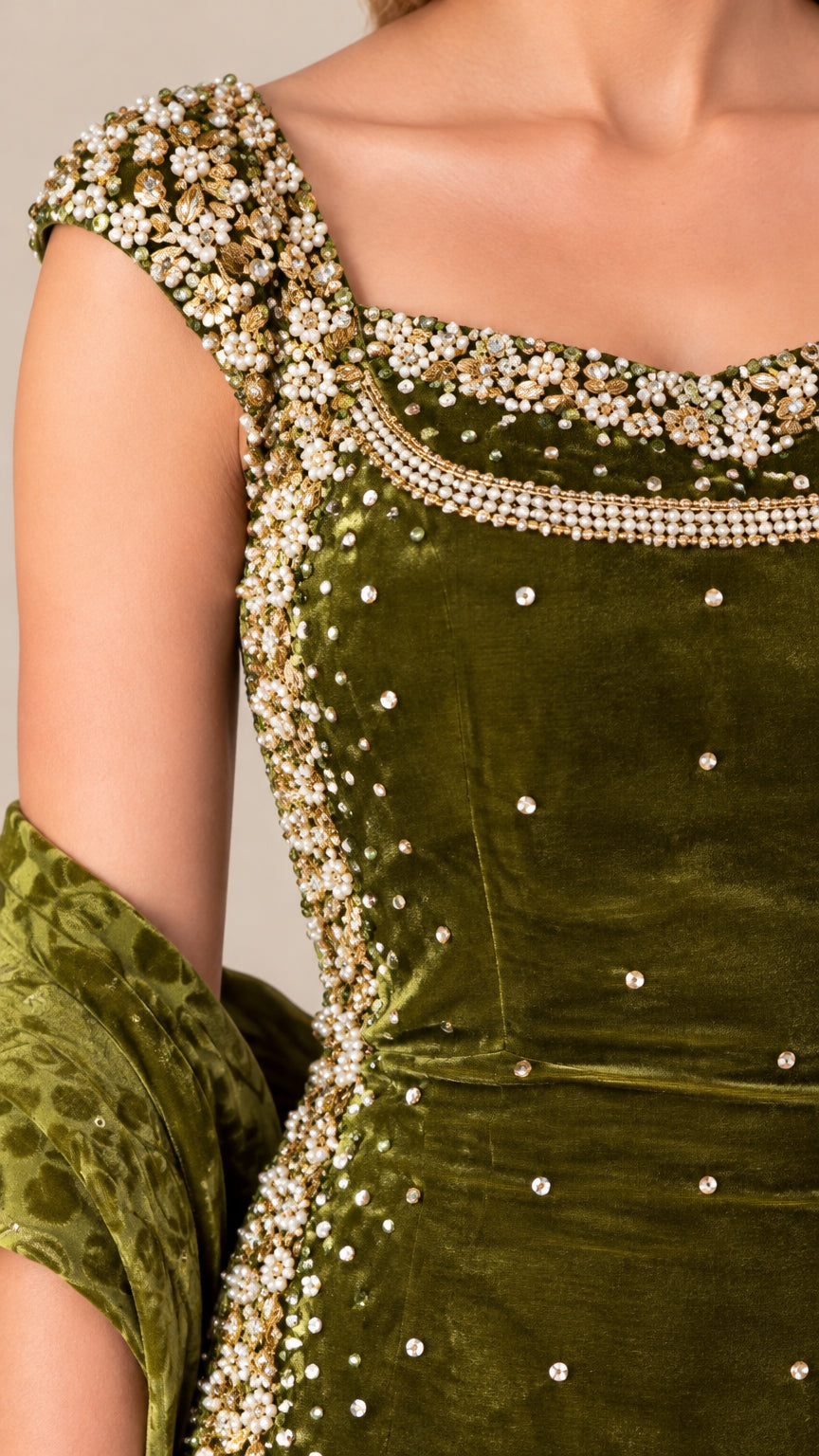 Close-up detail of pearl and bead embellishments on velvet neckline and shoulder