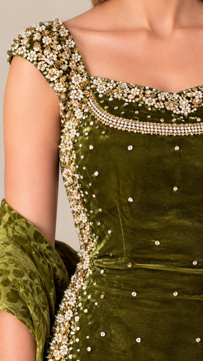 Close-up detail of pearl and bead embellishments on velvet neckline and shoulder