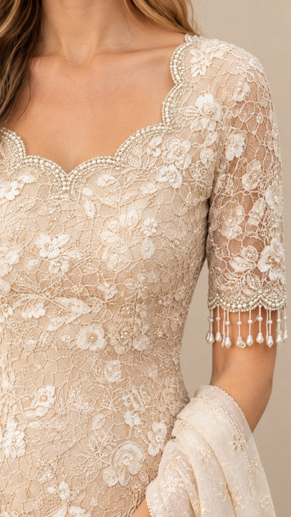 Close-up detail of beaded scalloped neckline and pearl fringe on lace half sleeve