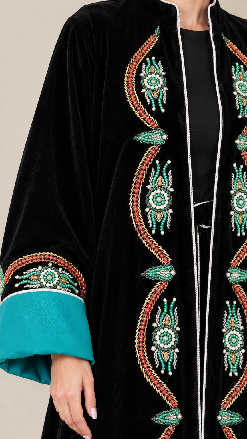 Close-up of intricate embroidery and contrast sleeve detail on black velvet abaya
