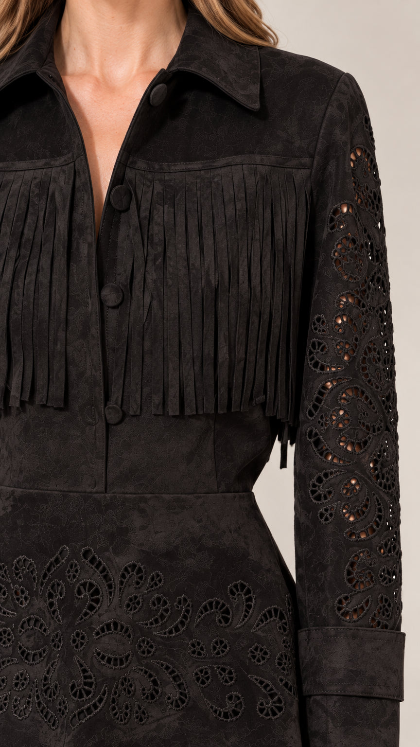 Close-up detail of black fringe yoke, collar, and cutwork embroidered sleeves