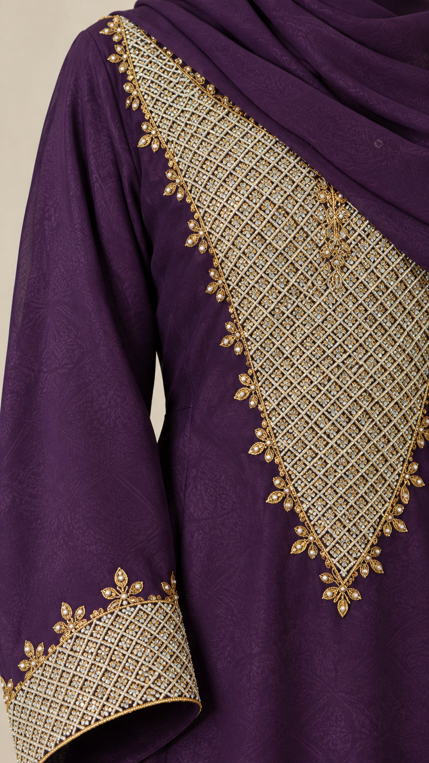 Close-up detail of golden lattice embroidery on purple woven fabric and cuff
