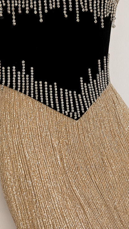 Close-up detail of rhinestone embellishments on contrast black waist panel and gold glitter fabric