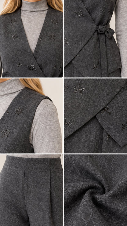 Close-up details of wrap vest tie, neckline, embroidered accents, and pleated trouser fabric