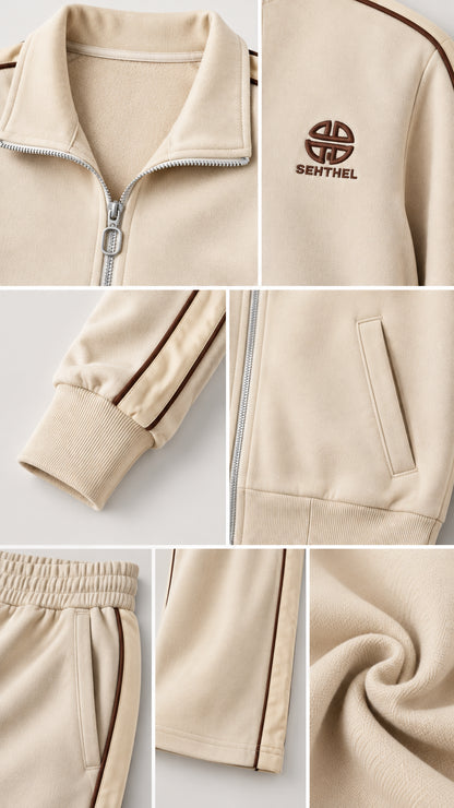 Close-up details of beige tracksuit collar, zip, chest embroidery, ribbed cuffs, and pockets