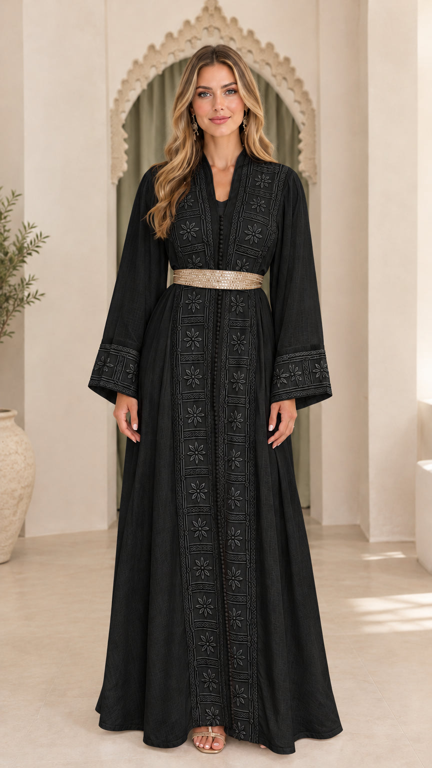 Model wearing black embroidered long sleeve abaya dress with metallic belt