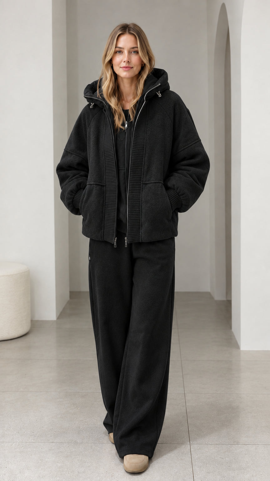 Front view of model wearing black textured fleece hooded zip-up jacket