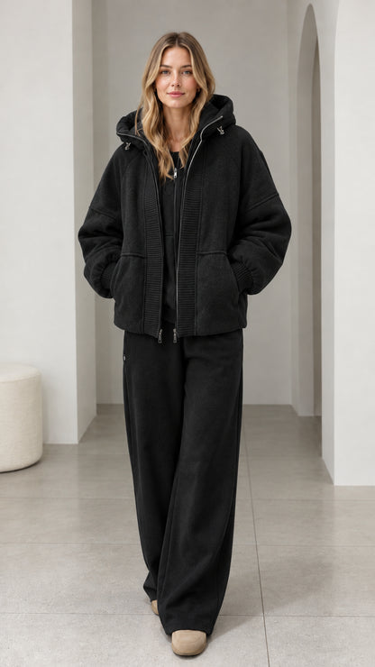 Front view of model wearing black textured fleece hooded zip-up jacket
