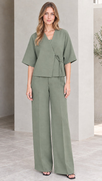 Full-length view of model wearing sage green wrap top and matching trousers