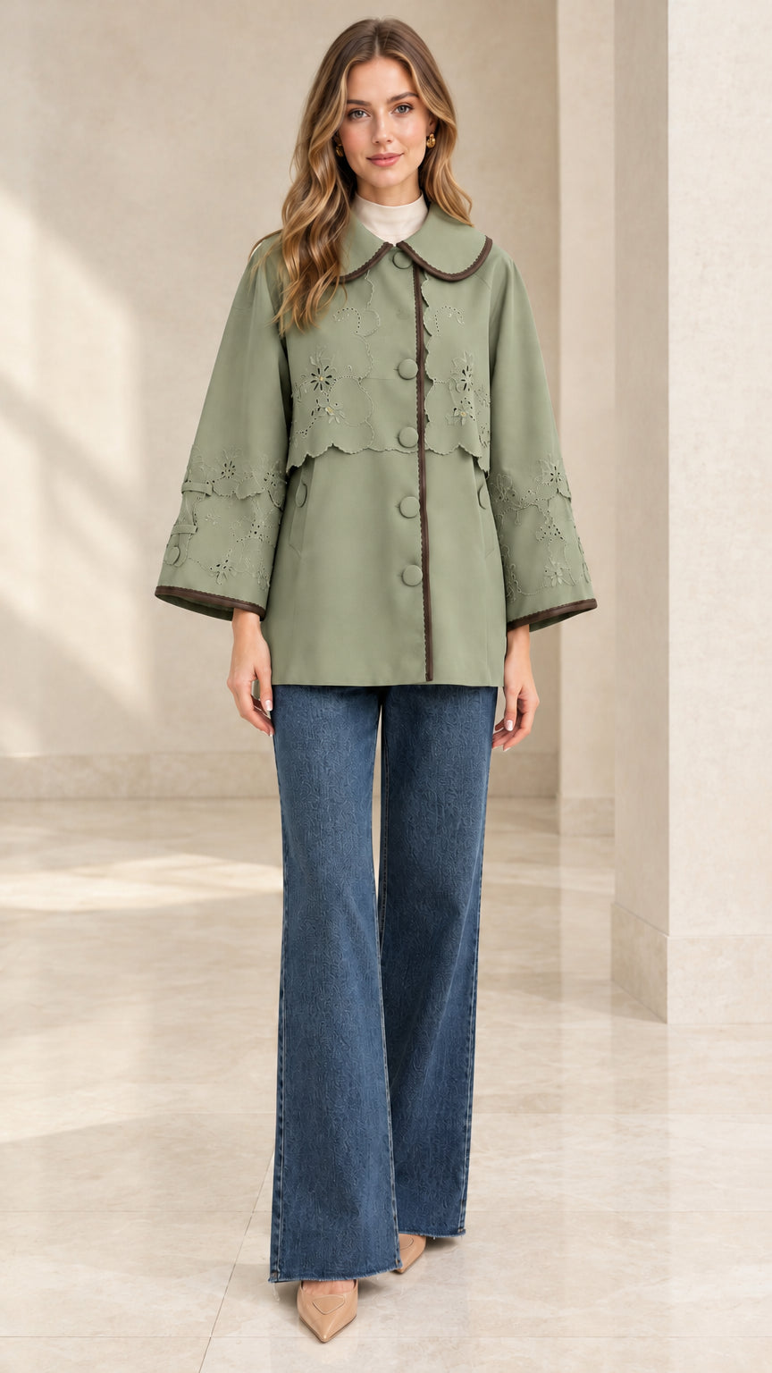 Full-length front view of woman wearing sage green embroidered scalloped capelet jacket