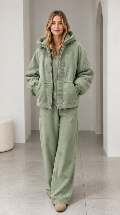 Front view of model wearing sage green textured fleece hooded zip-up jacket